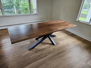 Walnut slab dining table on a black steel spider base by Four Fields Furniture, Minneapolis–St. Paul