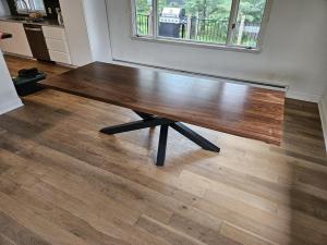 Walnut dining table with black steel spider base in a bright dining room, Minneapolis–St. Paul