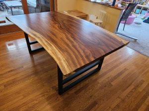 Parota live-edge slab dining table on a black steel base, Minneapolis–St. Paul