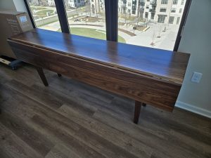 Long walnut console table in front of a large window, Minneapolis–St. Paul